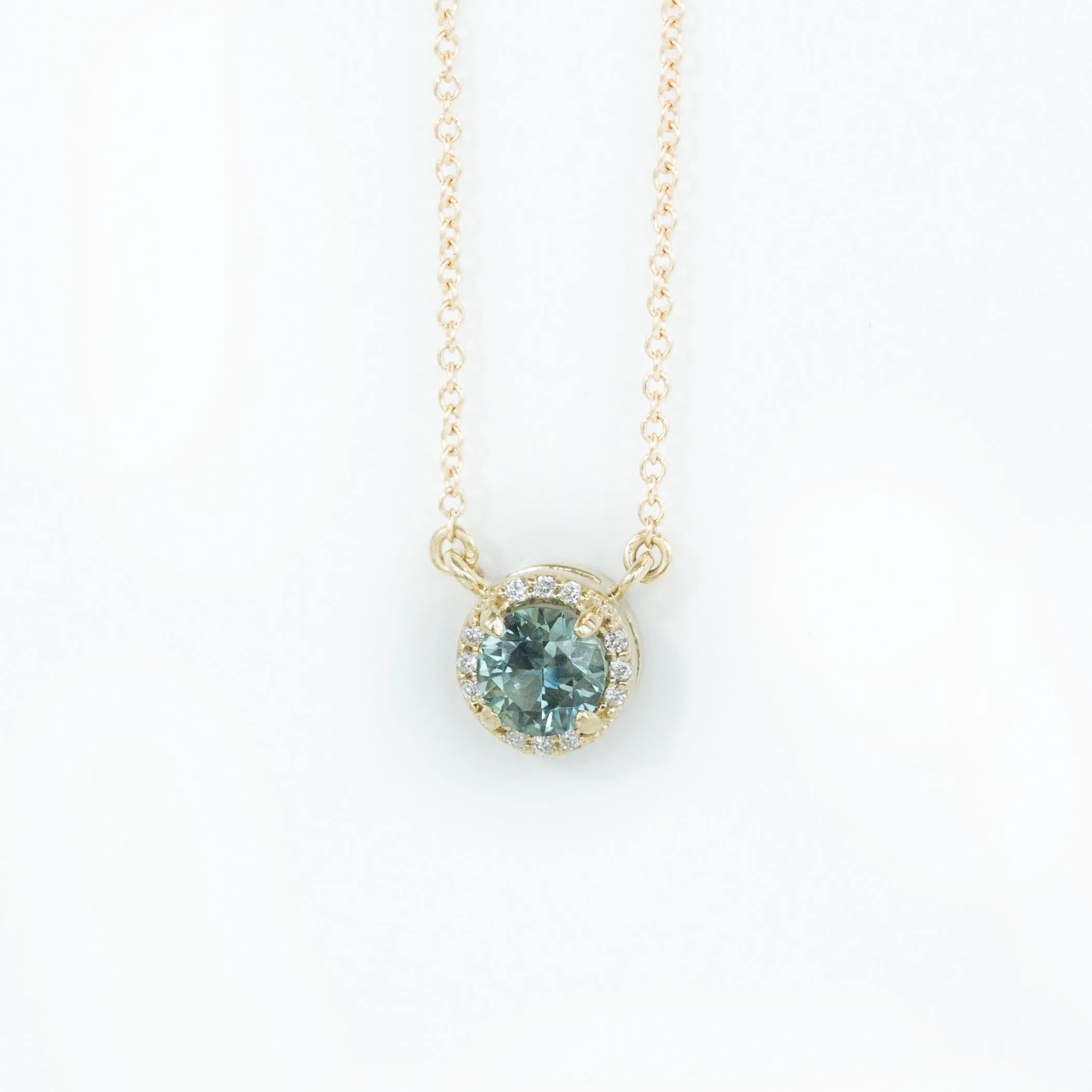 0.56ct Montana Sapphire and diamond halo necklace in 14k yellow